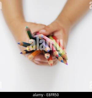 Boy's hands holding Coloured Pencils Banque D'Images