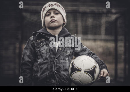 Portrait of a serious boy holding a football Banque D'Images