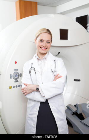 Portrait d'un médecin souriant debout à côté d'un scanner IRM dans un hôpital Banque D'Images