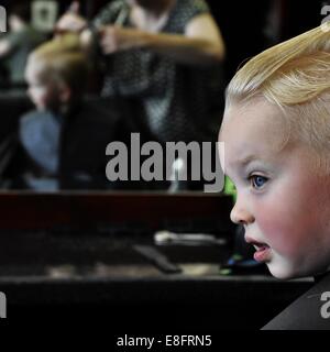 Garçon ayant une coupe de cheveux aux coiffeurs Banque D'Images