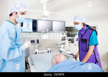 Chirurgien et les infirmières de l'analyse IRM avec patient en salle d'opération Banque D'Images