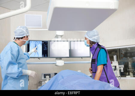 Chirurgien et les infirmières de l'analyse IRM avec patient en salle d'opération Banque D'Images