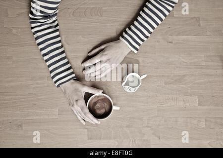 Vue en hauteur d'une femme assise à une table avec une tasse de café Banque D'Images