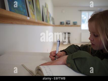 Fille assise à une table faisant ses devoirs, Suède Banque D'Images