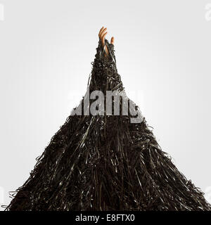 La main de l'homme sortant de tas de bandes d'enregistrement Banque D'Images