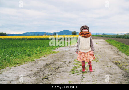 Fille debout dans un champ de tulipe regardant vers le haut Banque D'Images