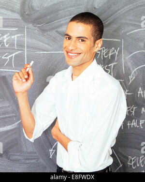 Businessman standing in front of blackboard au bureau Banque D'Images
