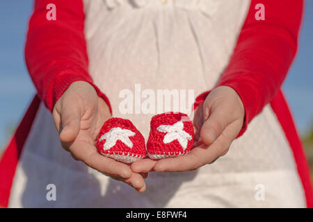 Espagne, Province de Guadalajara, Castille la Manche, Girl holding baby shoes Banque D'Images