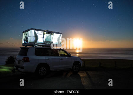 Tente de couchage sur le dessus de la voiture au coucher du soleil Banque D'Images