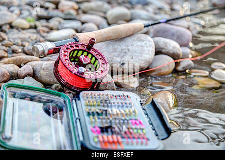 Gros plan d'un matériel de pêche sur une rive avec une canne à pêche Banque D'Images