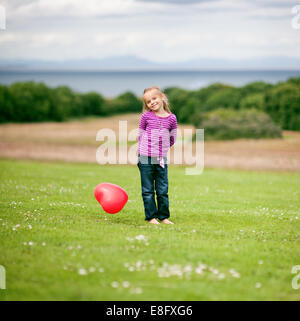 Girl (2-3) holding heart shaped balloon Banque D'Images