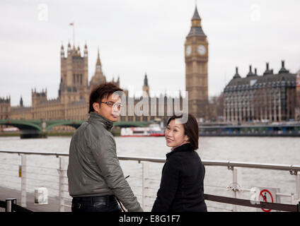 Couple asiatique chinois visitant Londres (de Singapour) se tenant la main devant les Maisons du Parlement Banque D'Images