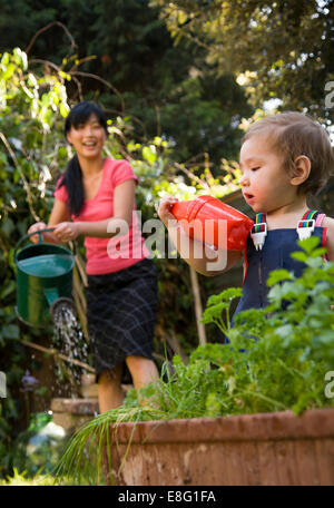 Une ethnicité mixte (East Asian / caucasian) female toddler dans le petit jardin urbain à la maison avec sa mère, de l'Asie de l'est t Banque D'Images