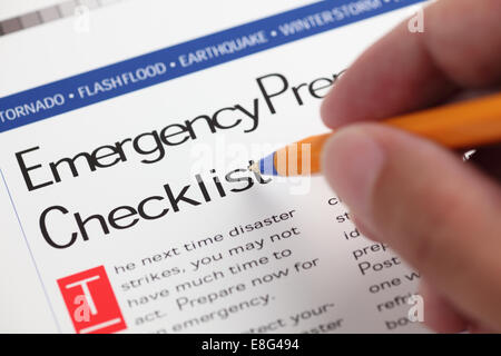 Liste de vérification en cas d'urgence et la main avec stylo à bille. Close-up. Banque D'Images