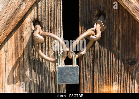 Porte en bois verrouillée avec un cadenas en métal Banque D'Images