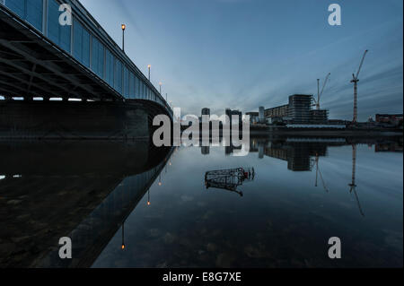 Un chariot de supermarché sous-évaluées sous un pont de la Tamise à marée basse Banque D'Images