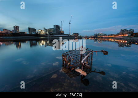 Un chariot de supermarché sous-évaluées sous un pont de la Tamise à marée basse Banque D'Images