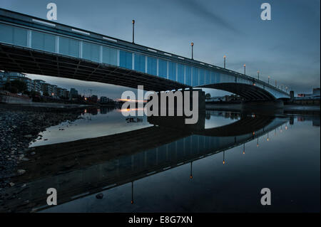 Un chariot de supermarché sous-évaluées sous un pont de la Tamise à marée basse Banque D'Images