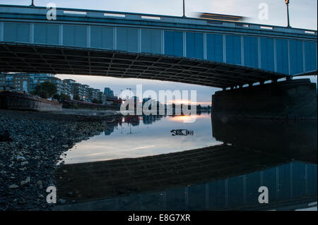 Un chariot de supermarché sous-évaluées sous un pont de la Tamise à marée basse Banque D'Images