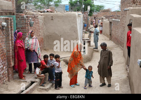 Les gens du village de boue entre les maisons d'un village près de Faisalabad, Pakistan Banque D'Images