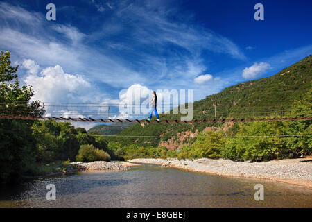 Des piétons sur le pont suspendu de la rivière Evinos, reliant les régions de Thermo et Nafpaktia, Heraklion, Grèce. Banque D'Images