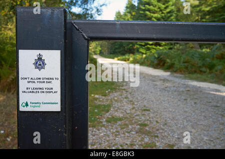 Signe de la police 'ne pas autoriser d'autres personnes à votre journée, du sol en laissant vos objets de valeur sur l'affichage'. La Forêt de Rendlesham, Suffolk, UK. Banque D'Images