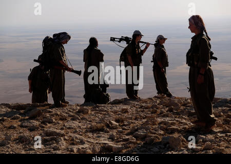 Un groupe de femmes des combattants kurdes des unités pour femmes libres raccourcie en YJA STAR l'aile militaire des femmes du Parti des Travailleurs du Kurdistan PKK lourdement armés stand dans une zone montagneuse dans la campagne de Makhmur près de Mossoul dans le Nord de l'Irak Banque D'Images