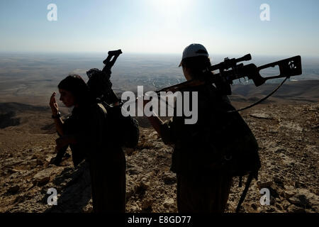 Un groupe de femmes des combattants kurdes des unités pour femmes libres raccourcie en YJA STAR l'aile militaire des femmes du Parti des Travailleurs du Kurdistan PKK lourdement armés à pied dans une zone montagneuse dans la campagne de Makhmur près de Mossoul dans le Nord de l'Irak Banque D'Images