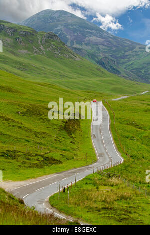 Vaste paysage spectaculaire et route étroite serpentant à travers les collines verdoyantes et les montagnes du Parc National de Cairngorms, en Écosse Banque D'Images
