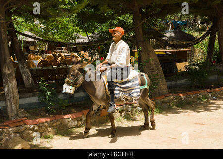 ALANYA, TURQUIE - 27 juin 2014 : habitant du village de divertir les touristes à cheval sur un âne Banque D'Images