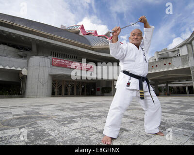 Masahiro Nakamoto - 10ème Dan Hanshi, Okinawa Kobudo Dentou avec nunchaku en dehors du Budokan, de la ville de Naha, Okinawa Banque D'Images