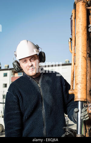 Young construction worker holding rod de la pelle Banque D'Images