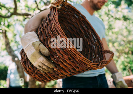 Portrait de l'homme exerçant son panier en osier at yard Banque D'Images