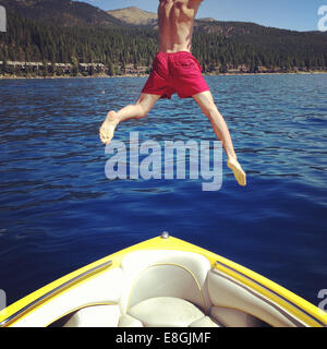 Homme sautant de bateau dans un lac, Lake Tahoe, Californie, États-Unis Banque D'Images