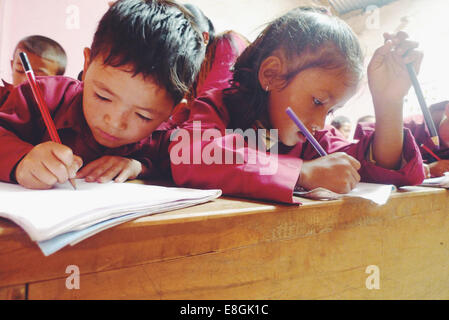 Enfants d'école écriture en classe, Népal Banque D'Images