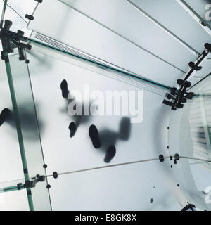 Low angle view of personnes marchant sur un sol en verre Banque D'Images