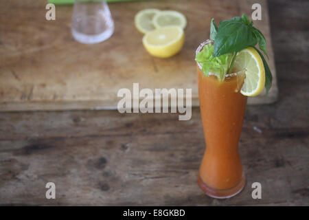 Cocktail Bloody Mary avec le citron, le céleri, le sel et le basilic Banque D'Images