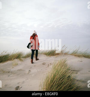 Vue arrière d'une femme marchant sur la plage en hiver, Strandslag 12, Duindorp Strand, pays-Bas Banque D'Images