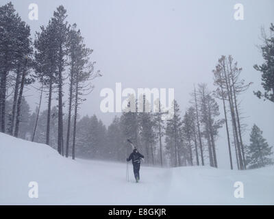 Vue arrière de l'homme de marcher jusqu'à la colline, ciel comptable Banque D'Images
