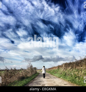 Woman walking down path Banque D'Images