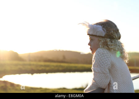 Coiffure de plumes girl looking at Lake Banque D'Images