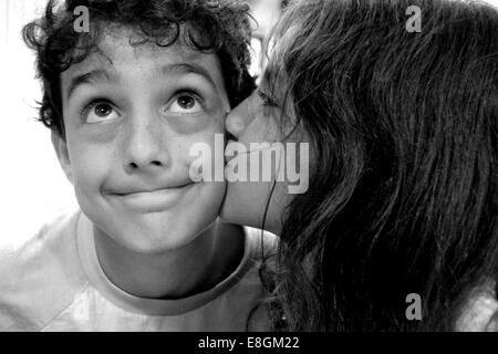 Girl kissing boy sur la joue Banque D'Images