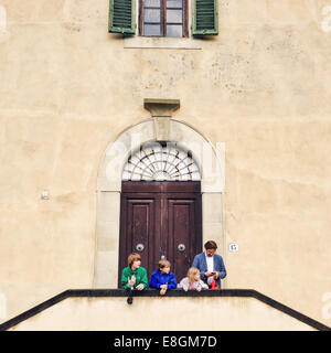 Père et trois enfants debout devant un bâtiment, Florence, Toscane, Italie Banque D'Images