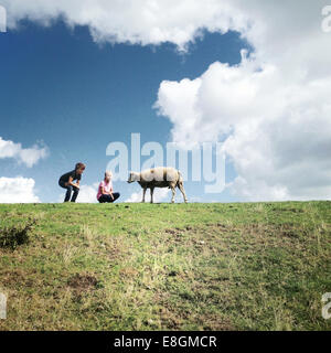 Deux enfants avec un mouton dans un champ Banque D'Images