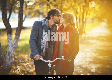 Jeune couple kissing in autumn park Banque D'Images