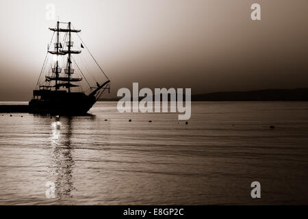 Magnifique coucher de soleil sur la mer. Voilier dans la baie. Tonifiant. Stylisation. Banque D'Images