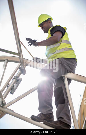 Low angle view of workers working on construction frame against sky Banque D'Images