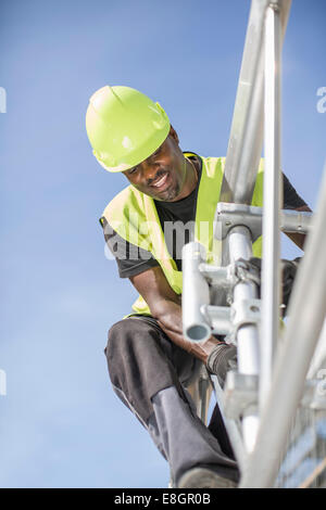 Low angle view of workers working on construction frame contre ciel clair Banque D'Images