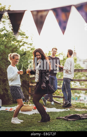 Female friends dancing at rooftop party Banque D'Images