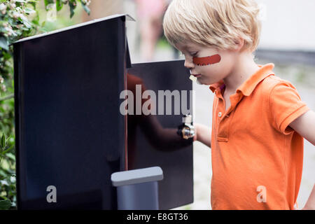 Garçon à la boîte aux lettres en plein air Banque D'Images